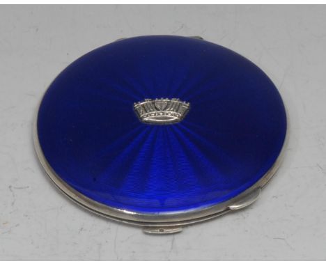 A George VI silver and enamel circular powder compact, hinged cover centred by a coronet, enclosing a mirror, engine turned b