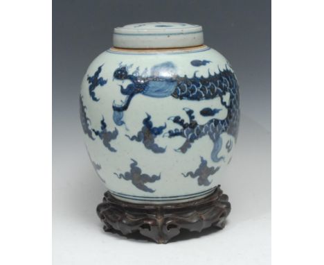 A Chinese ovoid ginger jar and cover, painted in underglaze blue with a ferocious dragon and scrolling clouds, the cover with
