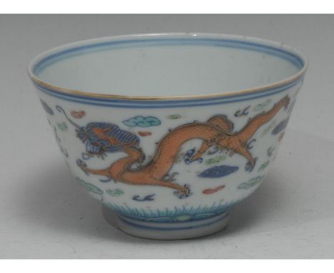 A Chinese wucai bowl, slightly flared and painted with phoenix and a dragon chasing a flaming pearl, the interior with double