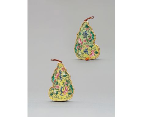 The plaque is of flat double gourd outline, inscribed in blue enamel on the front with the characters' zhai jie', upon overal
