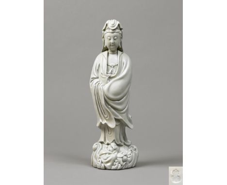 Finely modelled, the figure of the Bodhisattva standing barefoot on a base of swirling waves, with her head turned to one sid