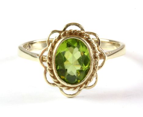 A 9ct yellow gold peridot set ring, (M).