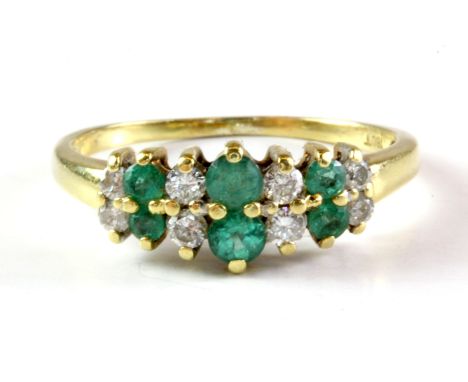 An 18ct yellow gold emerald and diamond set ring, (P).