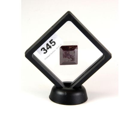 A step cut 127ct ruby in a display stand.
