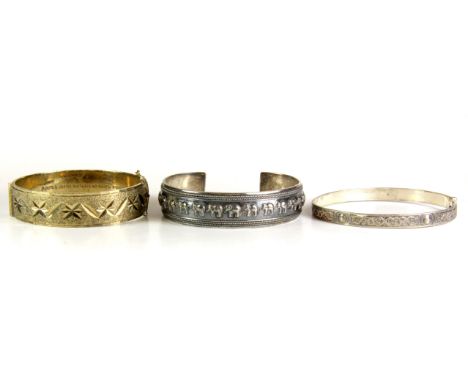 A hallmarked silver gilt bangle and two further bangles.