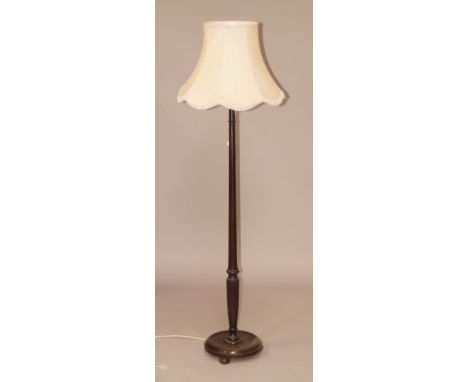 A turned mahogany standard lamp with shade.