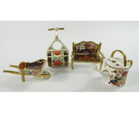 Four Royal Crown Derby imari pattern paperweights, comprising garden bench, garden roller, wheelbarrow and watering can.