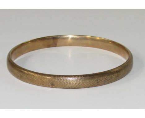 A 9ct gold bangle, with engine turned decoration, 12.7g.