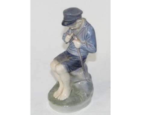 A Royal Copenhagen figure of a young seated boy, whittling a stick, No 905, 18.5cm high.