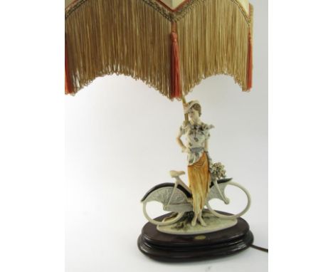 A Florence figural table lamp, with a young woman on bicycle, and with tasseled shade.