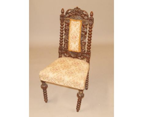 A Victorian oak Carolean style side chair, with a pierced carved back, padded seat on bobbin turned legs.