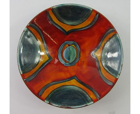 A modern Poole Delphis style bowl, of circular dished outline, decorated in a red, turquoise and blue geometric pattern, prin