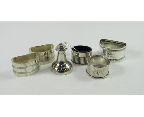 A pair of George V silver kidney shaped napkin rings, with engine turned decoration, a silver pepperette, a small salt pot wi