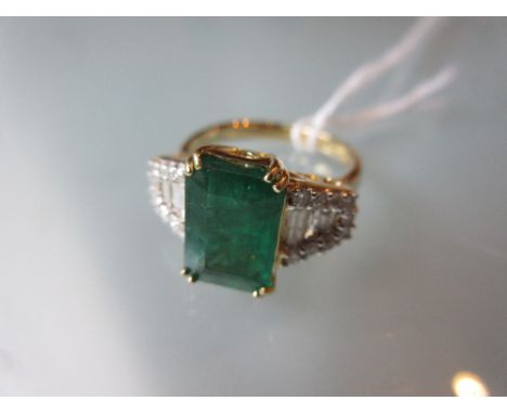 18ct Gold emerald and diamond ring, the central emerald of approximately 3.20ct flanked by baguette and brilliant cut diamond