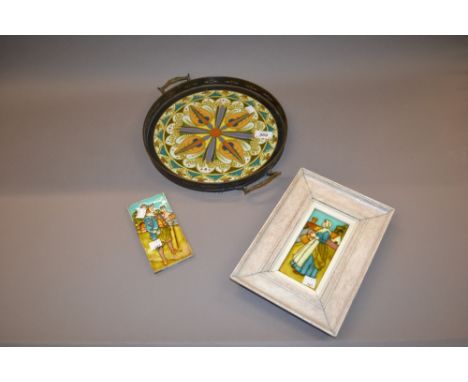 Two English tiles of a lady and gentleman, one framed, together with a circular two handled tray with ceramic base (at fault)