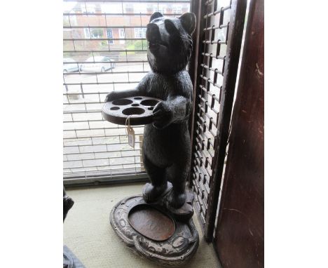 Late 19th or early 20th Century Black Forest carved and stained wood stick stand in the form of a bear on an oval base with d