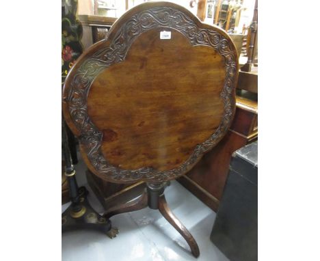 19th Century mahogany pedestal table, the shaped top with a carved rim on a baluster turned support and carved tripod base