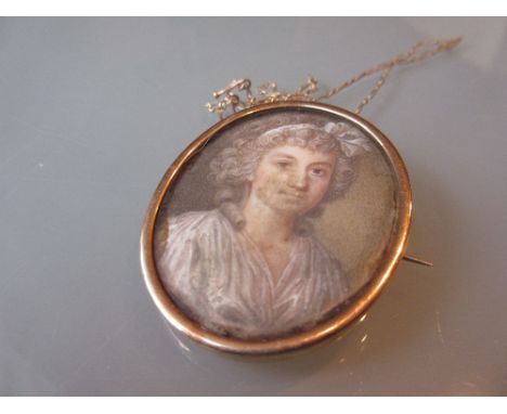 Small oval gold framed miniature head and shoulder watercolour portrait, lady with white bow in her hair on a gold safety cha