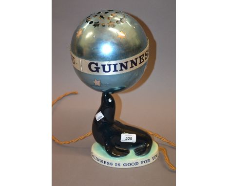 Original Carlton Ware ' Guinness is Good for You ' table lamp in the form of a seal holding a globe