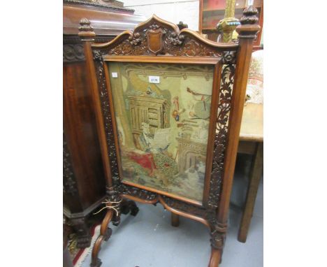 Victorian rosewood Gothic revival firescreen with a pierced floral border enclosing a petit point panel depicting a figure se
