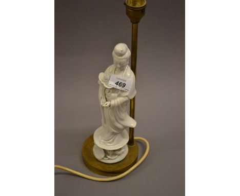 Blanc de chine figural lamp base on gilt metal stand and a Chinese floral baluster form vase on hardwood stand