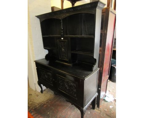 19th Century carved and ebonised oak dresser, the shelf back with a central mask head cupboard door, the base with two furthe