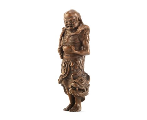 A Tall wood netsuke of Handaka SonjaEdo period (1615-1868), mid-late 19th centuryStanding barefoot with eyes downcast, dresse