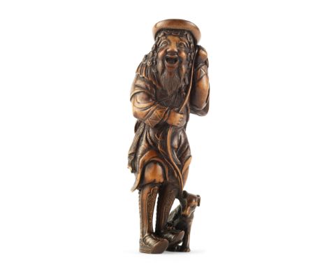 A Tall wood netsuke of a Dutchman and dogBy Ikko, Edo period (1615-1868), 19th centuryStanding and smiling, dressed in a trad