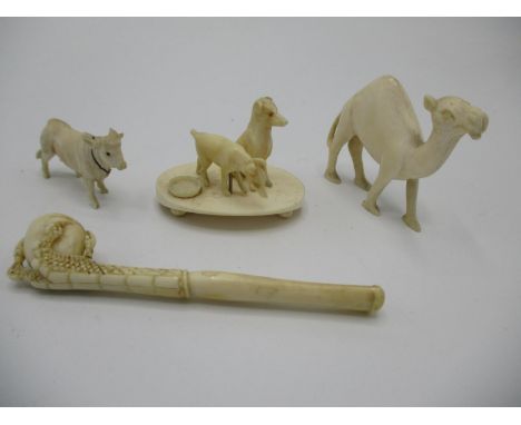 Early 20th century carved ivory model of a camel 1 3/4"h, two dogs by a bowl, on a stand 1 1/2"h, a cow 1" h and a Chinese op