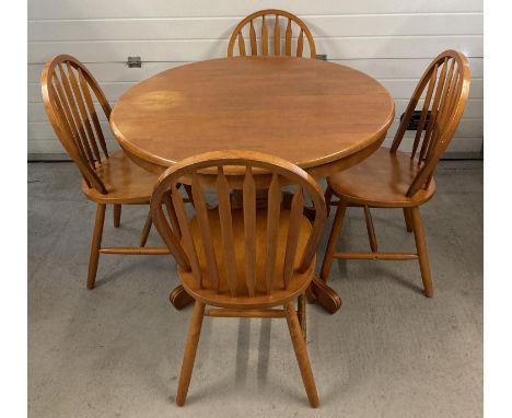 A modern light wood circular dining table and 4 chairs. 2 sectional draw leaf table with central fold out leaf and 4 footed p