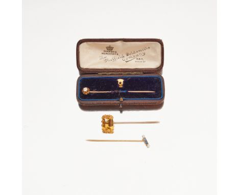 Three gem-set tie pins to include a rectangular step-cut citrine set pin, unmarked; a sapphire and pearl set stick pin, stamp