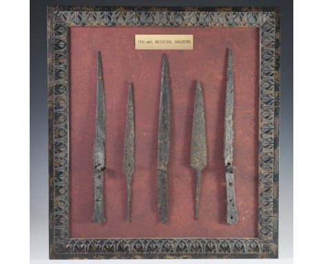 DESCRIPTION: 14th century Medieval daggers. Features 5 daggers set along with red background and wood frame. CIRCA: 14th Ct.O