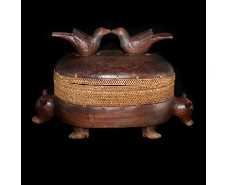 DESCRIPTION: Antique wooden box sits on four feet featuring two hand carved pig heads along the body. The opening of the box 