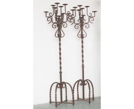 DESCRIPTION: Pair of vintage iron floor candelabras. Features four double tiered arms with scrolled accents that envelop the 