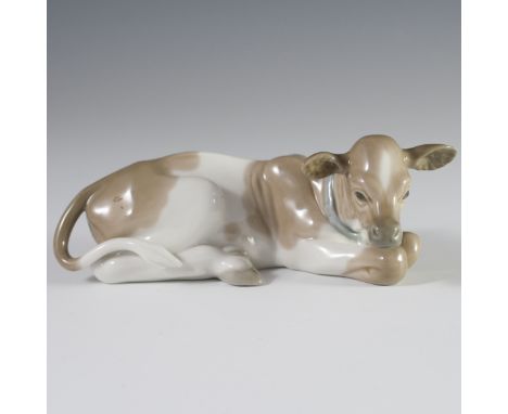 DESCRIPTION: Lladro porcelain figurine of a cow laying down with handpainted spots and finished with a glossed glaze. Marked: