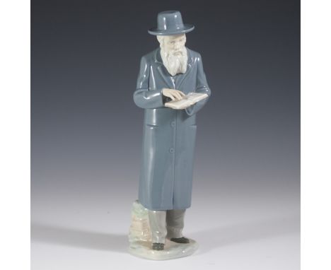 DESCRIPTION: Porcelain figurine by Nao of a Rabbi standing afront a boulder reading a prayer book. Finished with a glossed gl