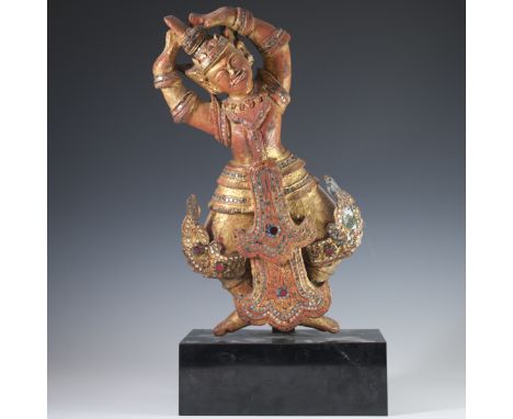 DESCRIPTION: A carved wooden dancing deity with gilded accents and bejeweled glass panels. Finished with black lacquered base
