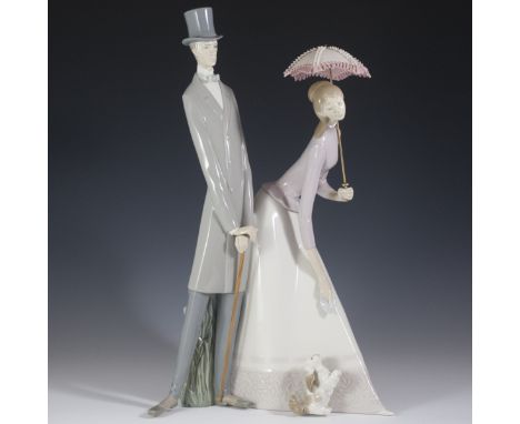 DESCRIPTION: Large Lladro porcelain figurine titled: "Couple with Parasol". Features a tall and slender man leaning on a cane