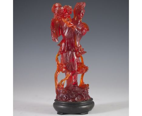 DESCRIPTION: Carved press amber figurine of Guanyin holding a basket of flowers, enveloped with winding ribbons and amber bas