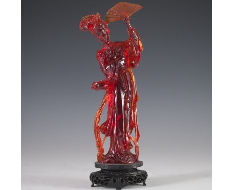 DESCRIPTION: Carved Chinese pressed amber figurine of a regal woman with a fan, as well as long flowing garments, holding a r