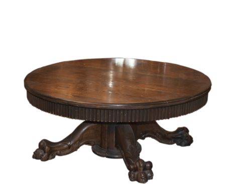 DESCRIPTION: Carved wooden coffee table featuring an intricately ridged under-border beneath the circular wooden top. Rests u