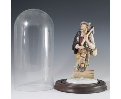 DESCRIPTION: Wallendorf porcelain figurine of a man with a wood cutting axe sheathed on his shoulder, and his right leg upon 