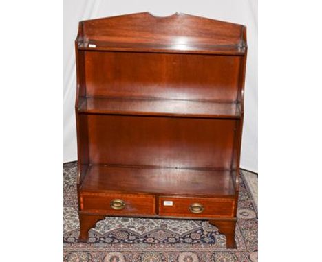 An early 20th century mahogany waterfall bookcase, cross banded incorporating two-drawers and raised on splay bracket feet, 7