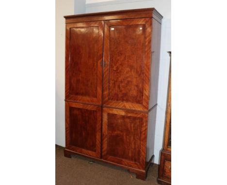 A Victorian figured mahogany double wardrobe with panelled doors, raised on bracket feet, 129cm by 51cm by 217cm 