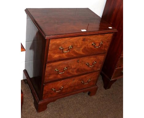 A George III figured mahogany three-height chest of small proportions with oak drawer lining and raised on bracket feet, 63cm