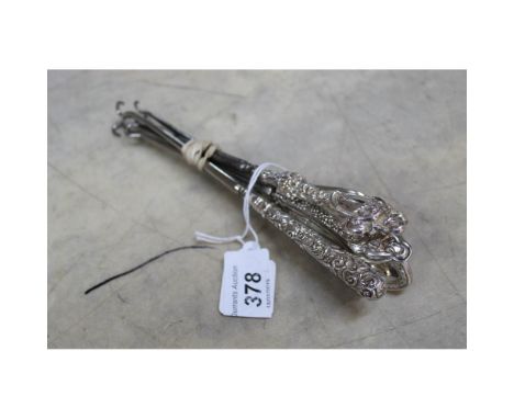 Six silver handled button hooks