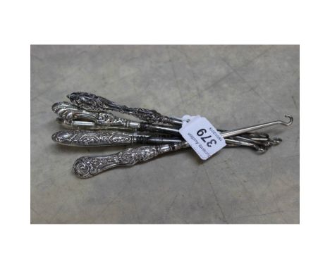 Six silver handled button hooks