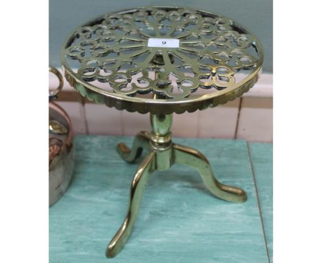 A heavy 19th Century brass trivet in the form of a tripod table with pierced circular top, 10 3/4" high