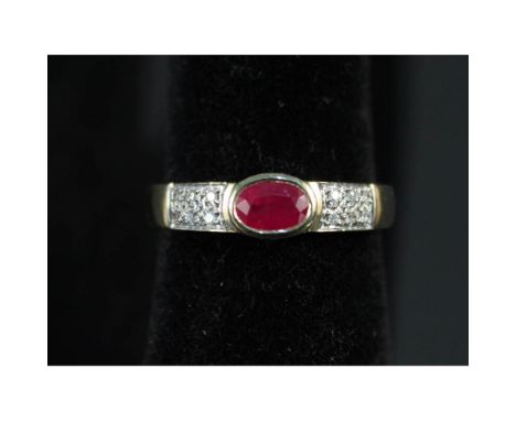 A 14ct gold ruby and diamond ring, the central oval ruby flanked by diamond encrusted shoulders, size Q