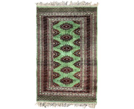 Persian Bokhara jade ground rug, the field decorated with Gul motifs, within a geometric multi-band border with lozenge patte